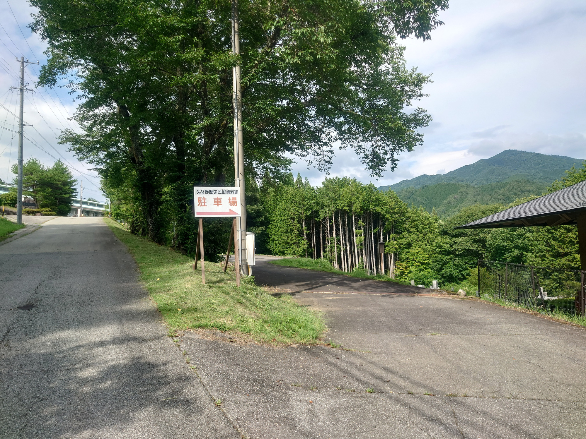 ⑲駐車場はもう少し進んだ先、資料館の裏側にあります。この道をさらに直進した先に久々野中学校があります。