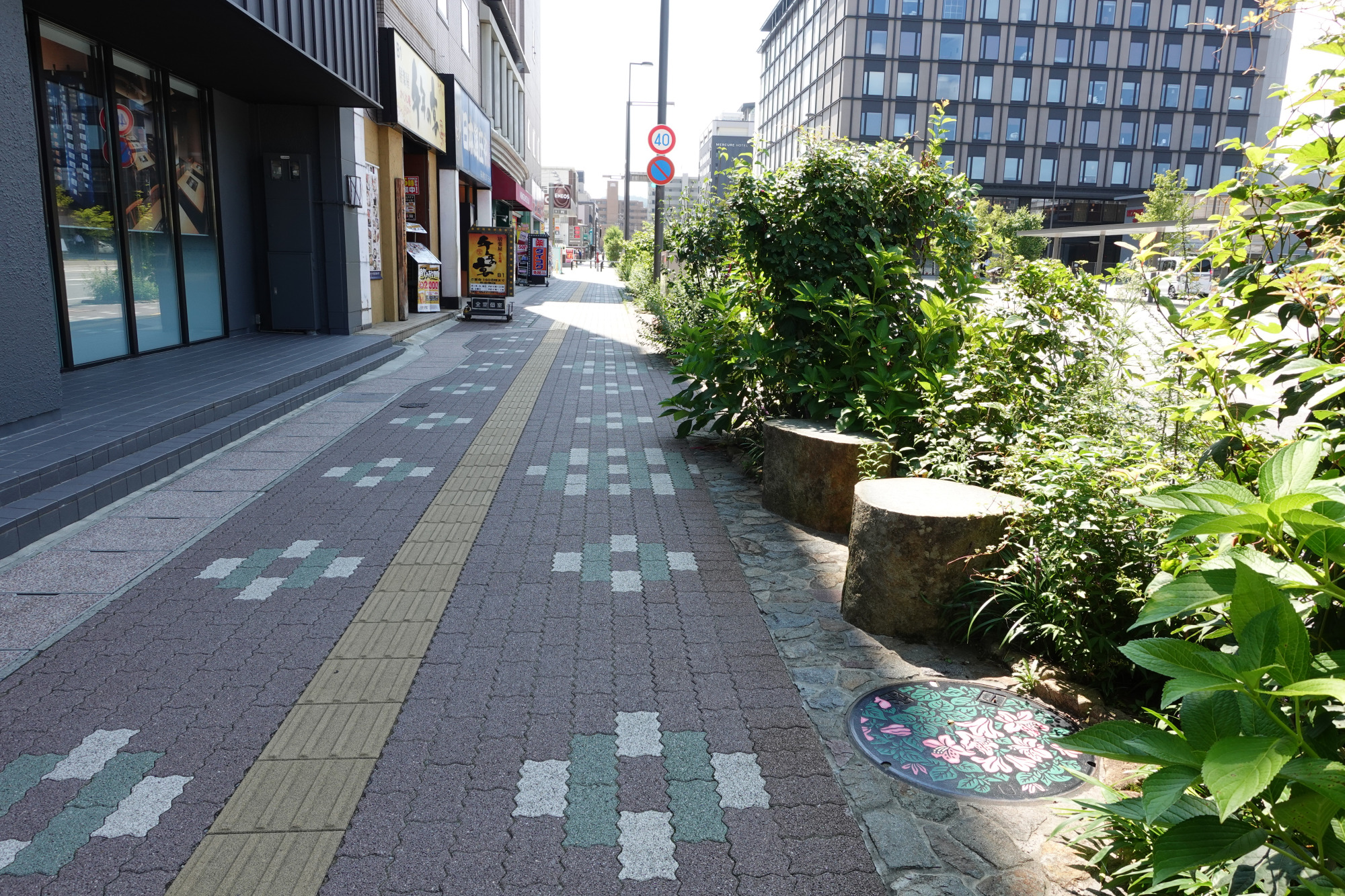 左手の建物が「ワシントンホテル」です。蓋は歩道の茂みに隠れているので、うっかり通り過ぎないようお気をつけてください。