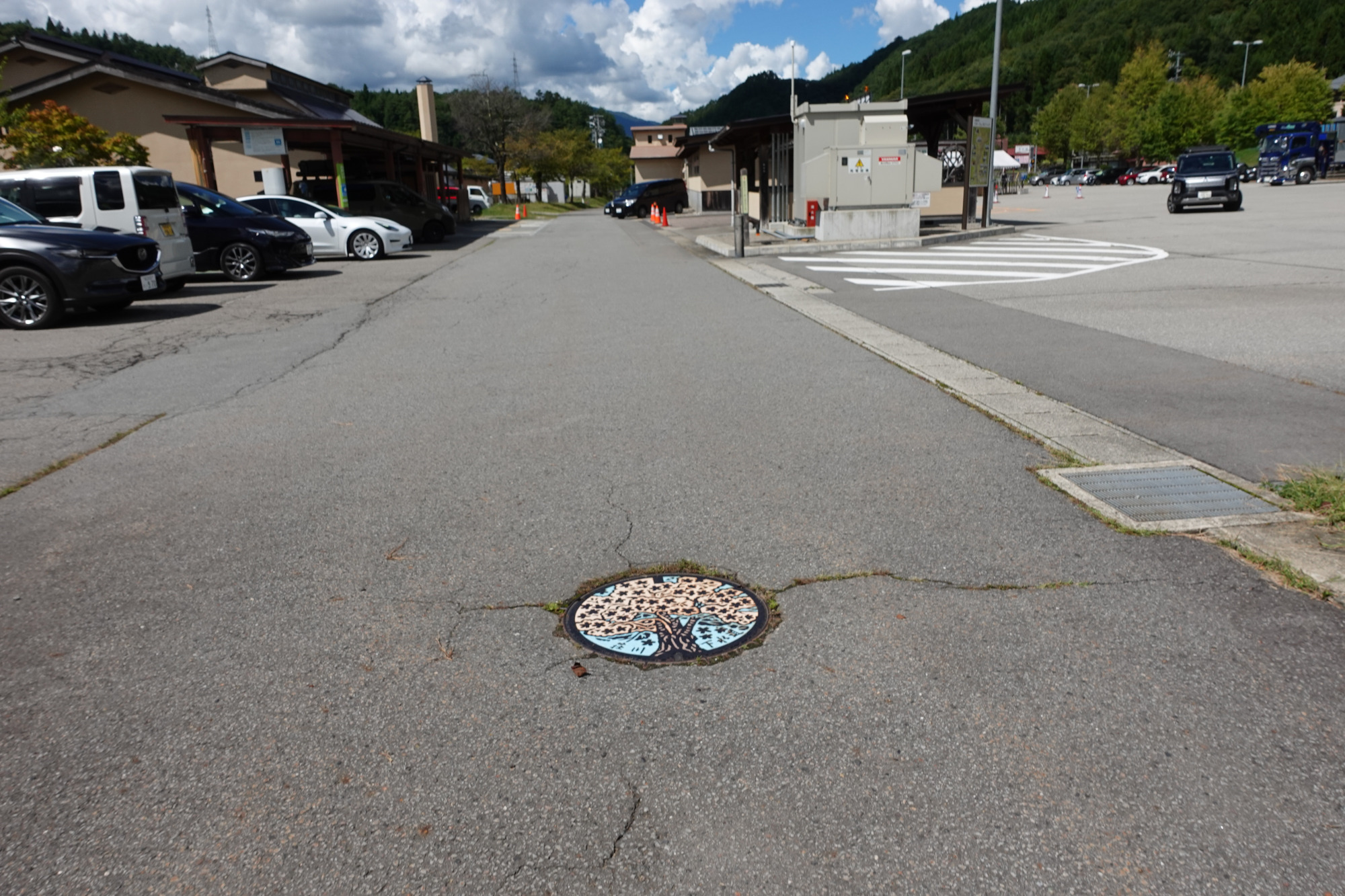 カラーマンホールを間に挟んで、左奥の建物は「桜花の湯」、中央奥が「道の駅 桜の郷 荘川」です。