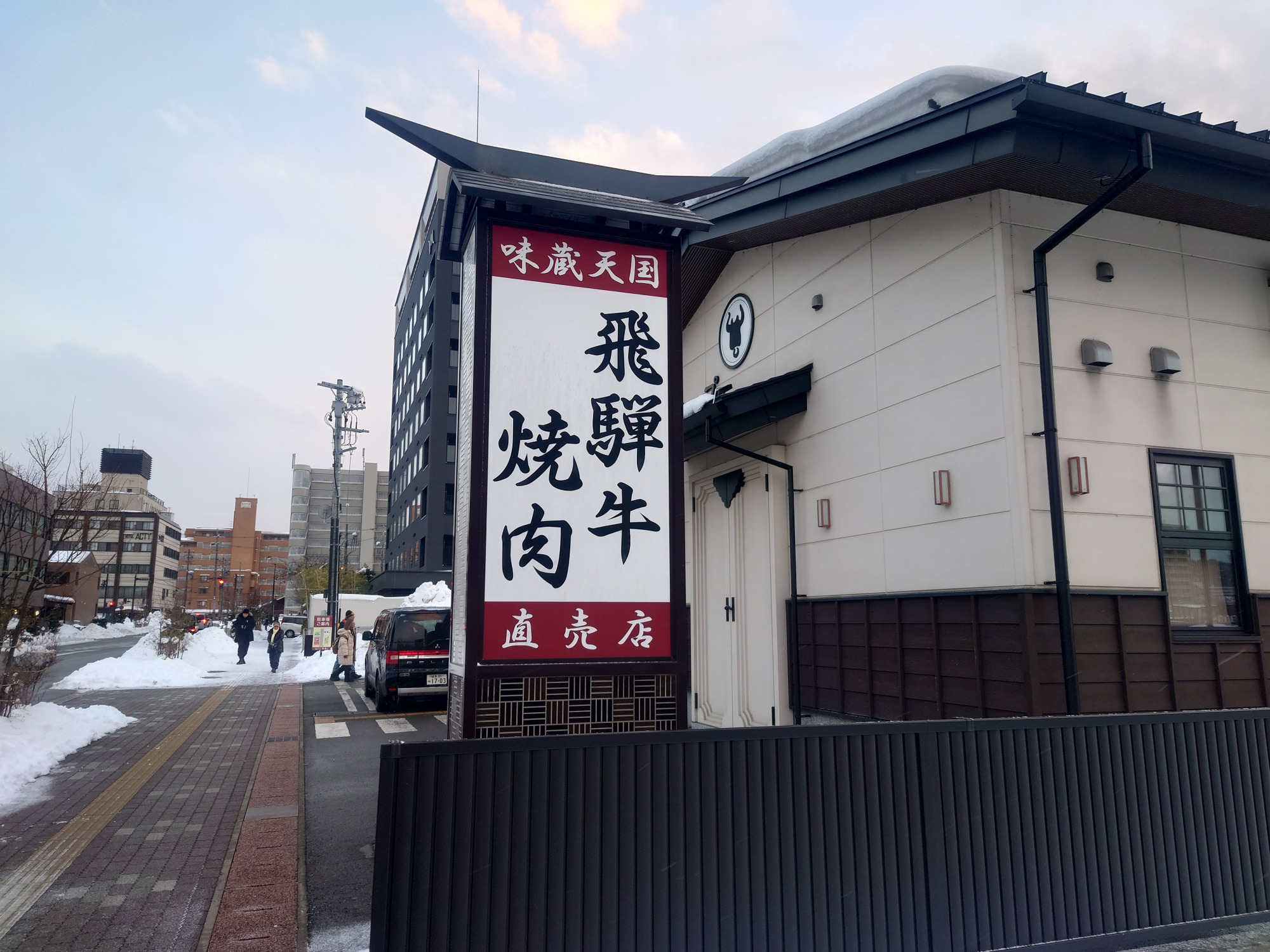 ④さらに直進すると「飛騨牛焼肉」の看板が見えてきます。この白い壁の建物が「味蔵天国」です。